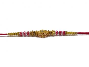 RAKHI Designed With a Golden Flower Pink Beads and White Diamonds RAKHI Designed With a Golden Flower Pink Beads and White Diamonds