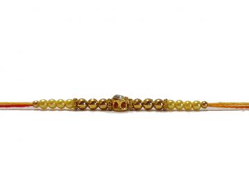 Diamond RAKHI Designed W/ Golden and Yellow Beads Diamond RAKHI Designed W/ Golden and Yellow Beads