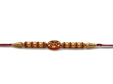 Swastika RAKHI in Gold W/ Red Beads and Diamonds