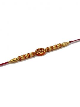 Swastika RAKHI in Gold W/ Red Beads and Diamonds