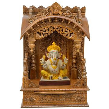 Show the interior of the torana wooden mandir with a deity or spiritual figure prominently displayed.
