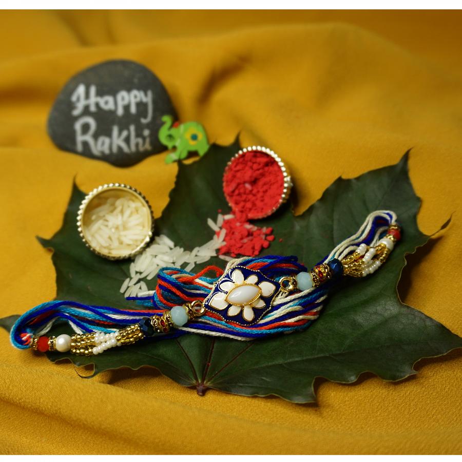 Auspicious Blue Meena Rakhi Surrounded By Small beads + Roli & Chaval Auspicious Blue Meena Rakhi Surrounded By Small beads + Roli & Chaval