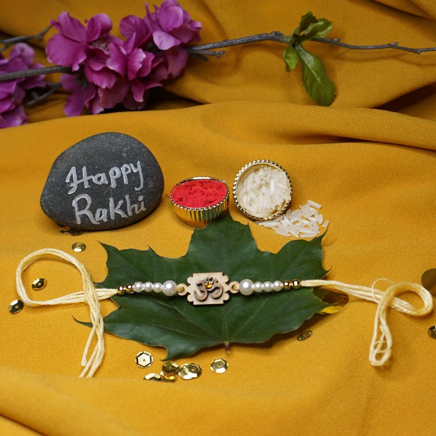 Wooden Om Carved RAKHI With White Beads and Diamond + Roli & Chaval Wooden Om Carved RAKHI With White Beads and Diamond + Roli & Chaval