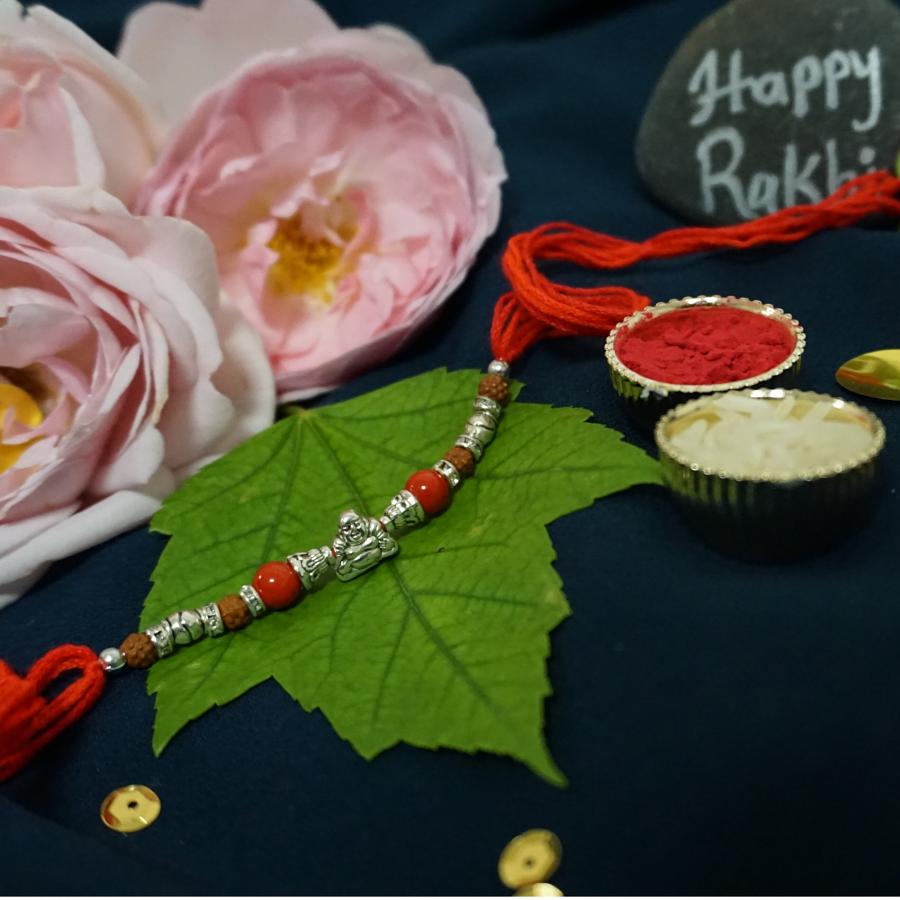 Adorable Silver laughing Buddha Rakhi W/ Cute Beads + Roli & Chaval Adorable Silver laughing Buddha Rakhi W/ Cute Beads + Roli & Chaval