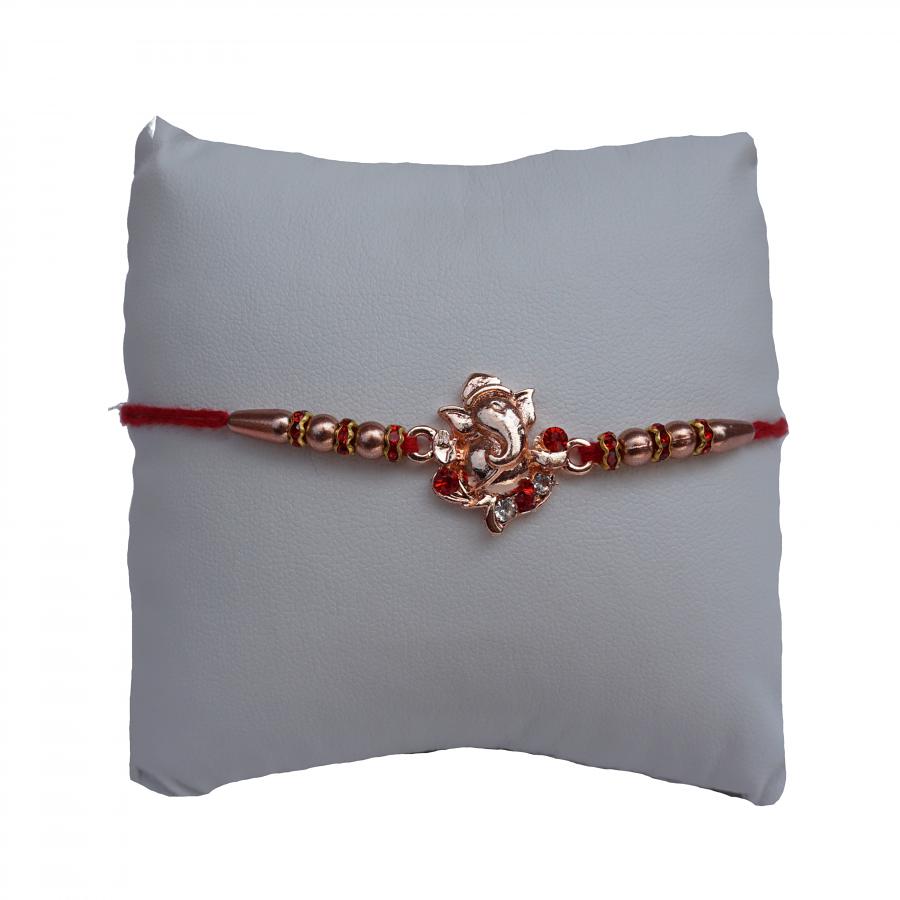 Rose Gold Ganesh Ji RAKHI W/ Red Diamonds + Roli & Chaval Rose Gold Ganesh Ji RAKHI W/ Red Diamonds + Roli & Chaval