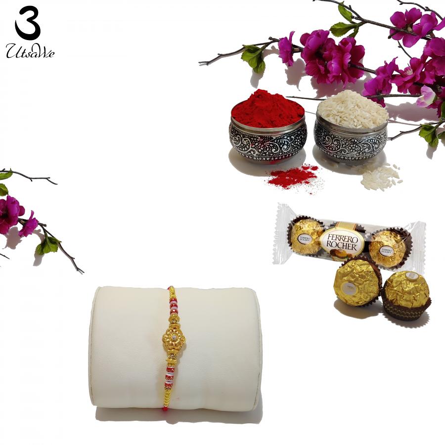 RAKHI Designed With a Golden Flower Red Beads and White Diamonds RAKHI Designed With a Golden Flower Red Beads and White Diamonds