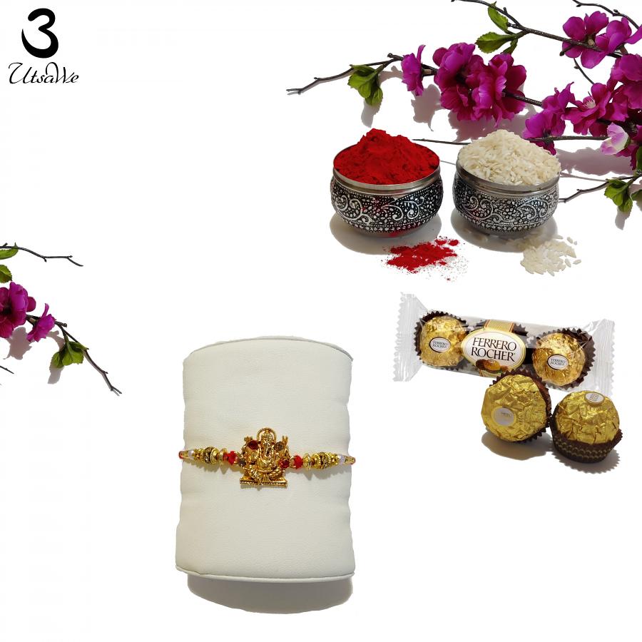 Golden Ganesh Rakhi W/ Rubies & Handcrafted Ornaments + Roli & Chaval Golden Ganesh Rakhi W/ Rubies & Handcrafted Ornaments + Roli & Chaval