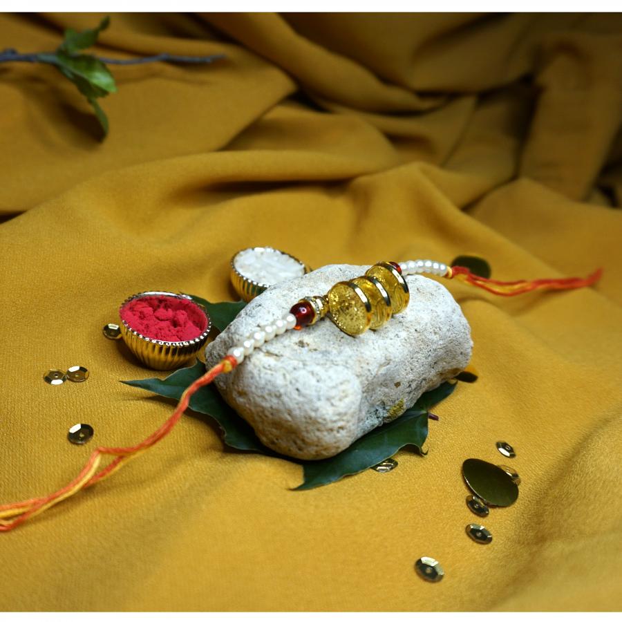 Beautiful Golden Gini Rakhi With Tiny White Beads + Roli & Chaval Beautiful Golden Gini Rakhi With Tiny White Beads + Roli & Chaval