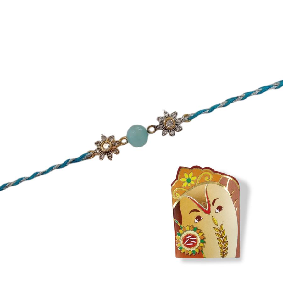 Cute silver flower rakhi with blue beads + Roli & Chaval