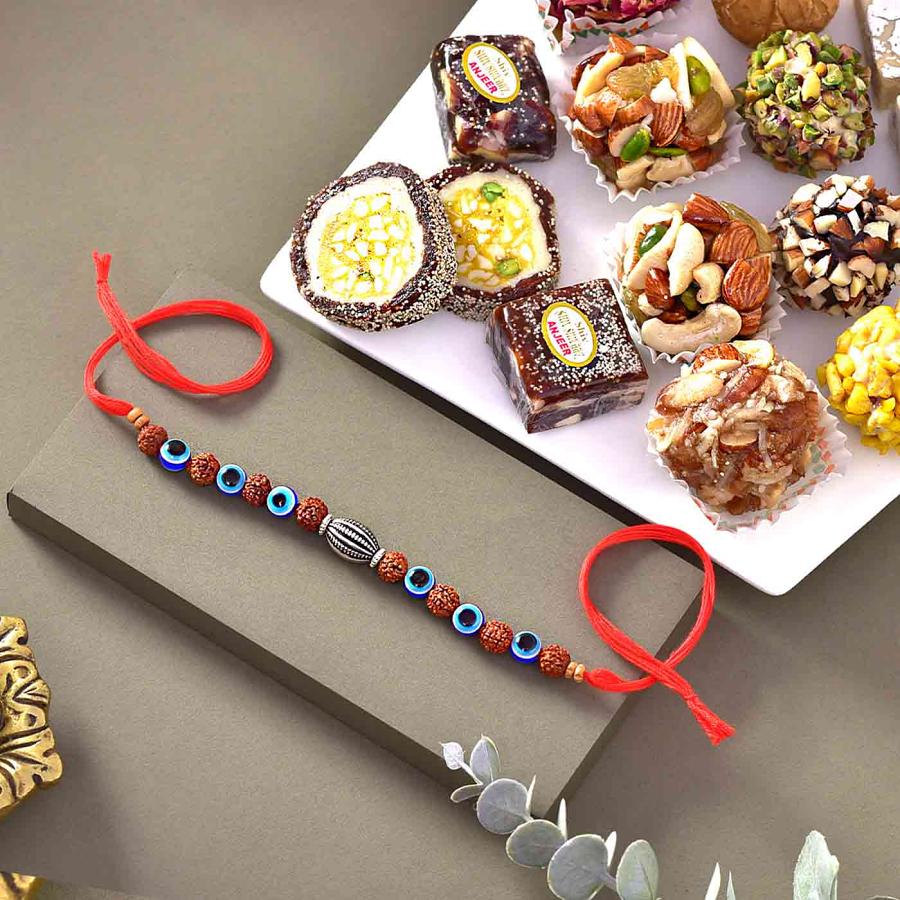 Beaded Evil Eye and Rudraksha Rakhi with 12 pcs. Assorted Sweets Beaded Evil Eye and Rudraksha Rakhi with 12 pcs. Assorted Sweets