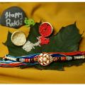 Auspicious Red Meena Rakhi With American diamonds On Top + Roli & Chaval Auspicious Red Meena Rakhi With American diamonds On Top + Roli & Chaval