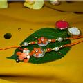 Elegant Bhaiya Bhabhi Rakhi With An Orange Flower on stone + Roli/Chaval