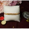 Exquisite Golden Rakhi With Diamonds and Beads + Roli & Chaval Exquisite Golden Rakhi With Diamonds and Beads + Roli & Chaval