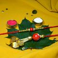 Simple And Classy Red Bead Couple Rakhi + Roli & Chaval Simple And Classy Red Bead Couple Rakhi + Roli & Chaval
